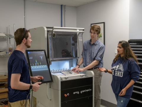 Students standing around makerspace equipment