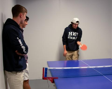 Student hitting table tennis ball 